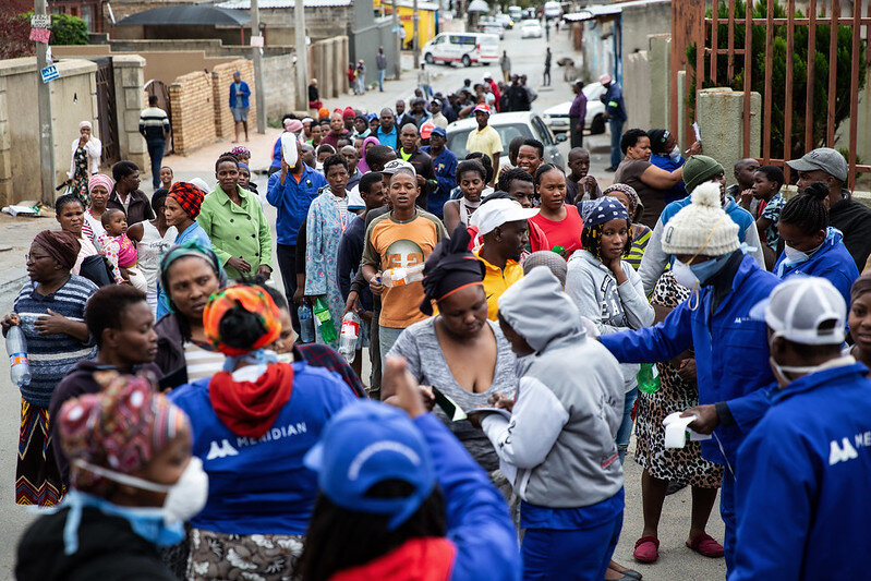 Menschen stehen Schlange, um Handdesinfektionsmittel während des Lockdowns im Alexandra Township, Johannesburg, nachzufüllen. Foto: International Monetary Fund/flickr, CC BY-NC-ND 2.0<br>