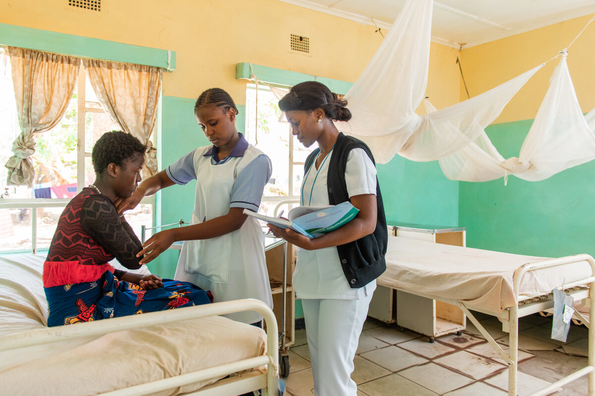 Student nurse attending a patient, overseen by a Clinical Instructor at St. Luke's Mission Hospital in Mpanshya, Zambia. Photo by Gareth Bentley